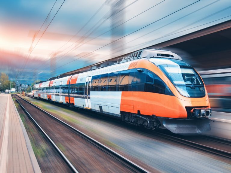 train passing through a railway station at high speed with a blurred background